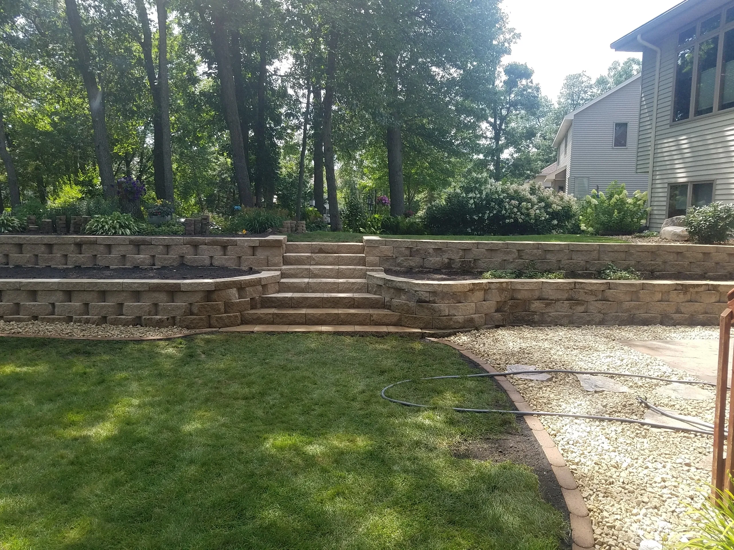 A backyard with steps and grass in the middle of it.