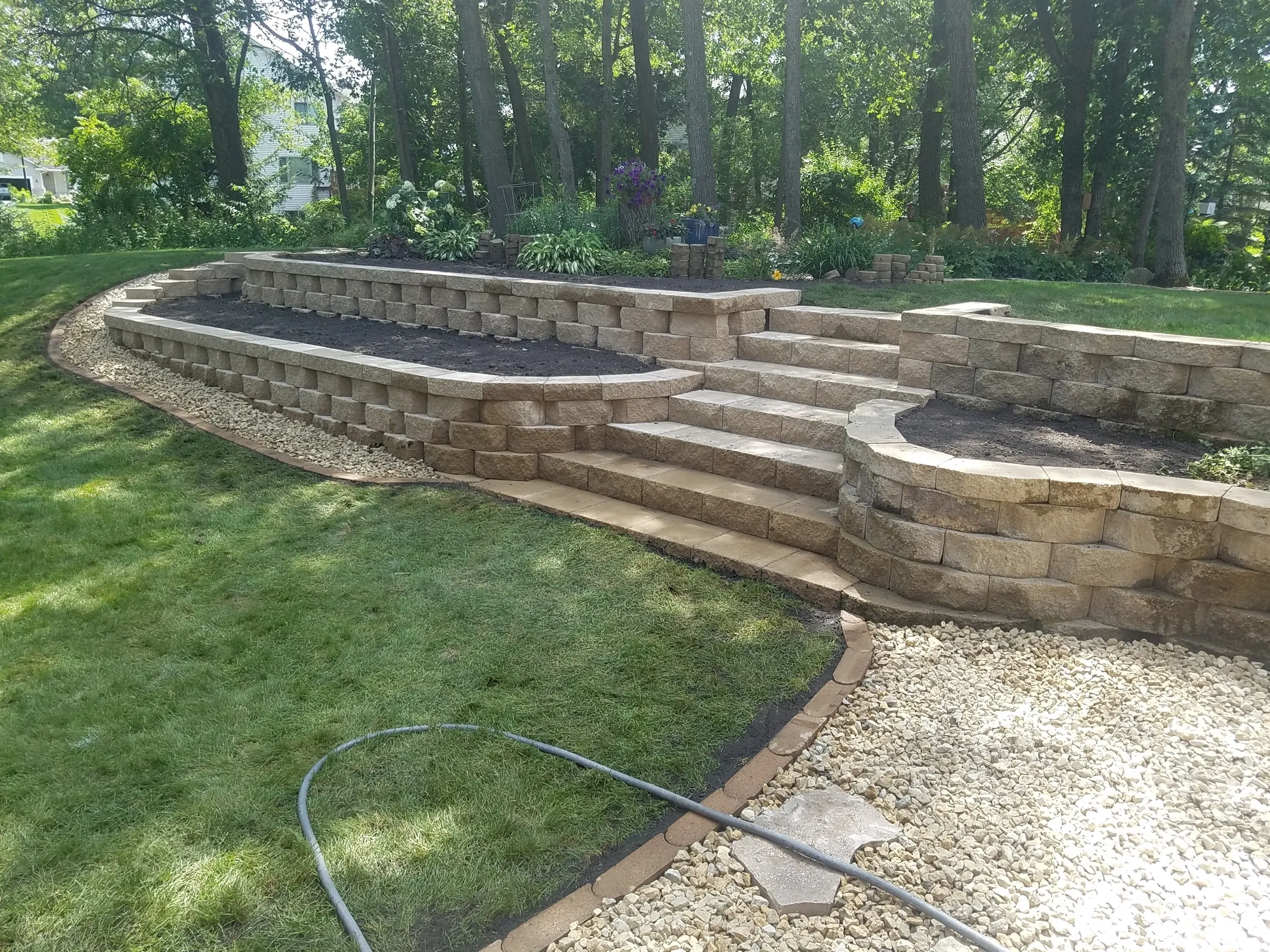 A patio with steps and fire pit in the middle of it.