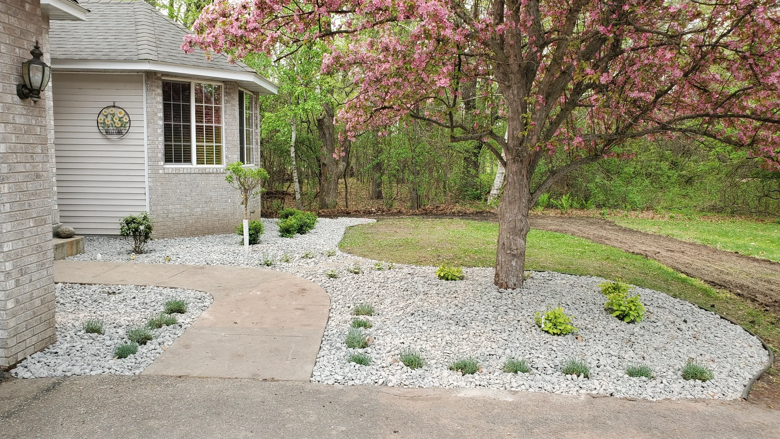 A house with a tree and bushes in the background