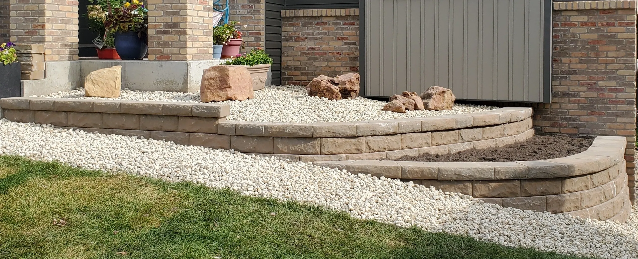 A stone wall with steps and rocks in the yard.