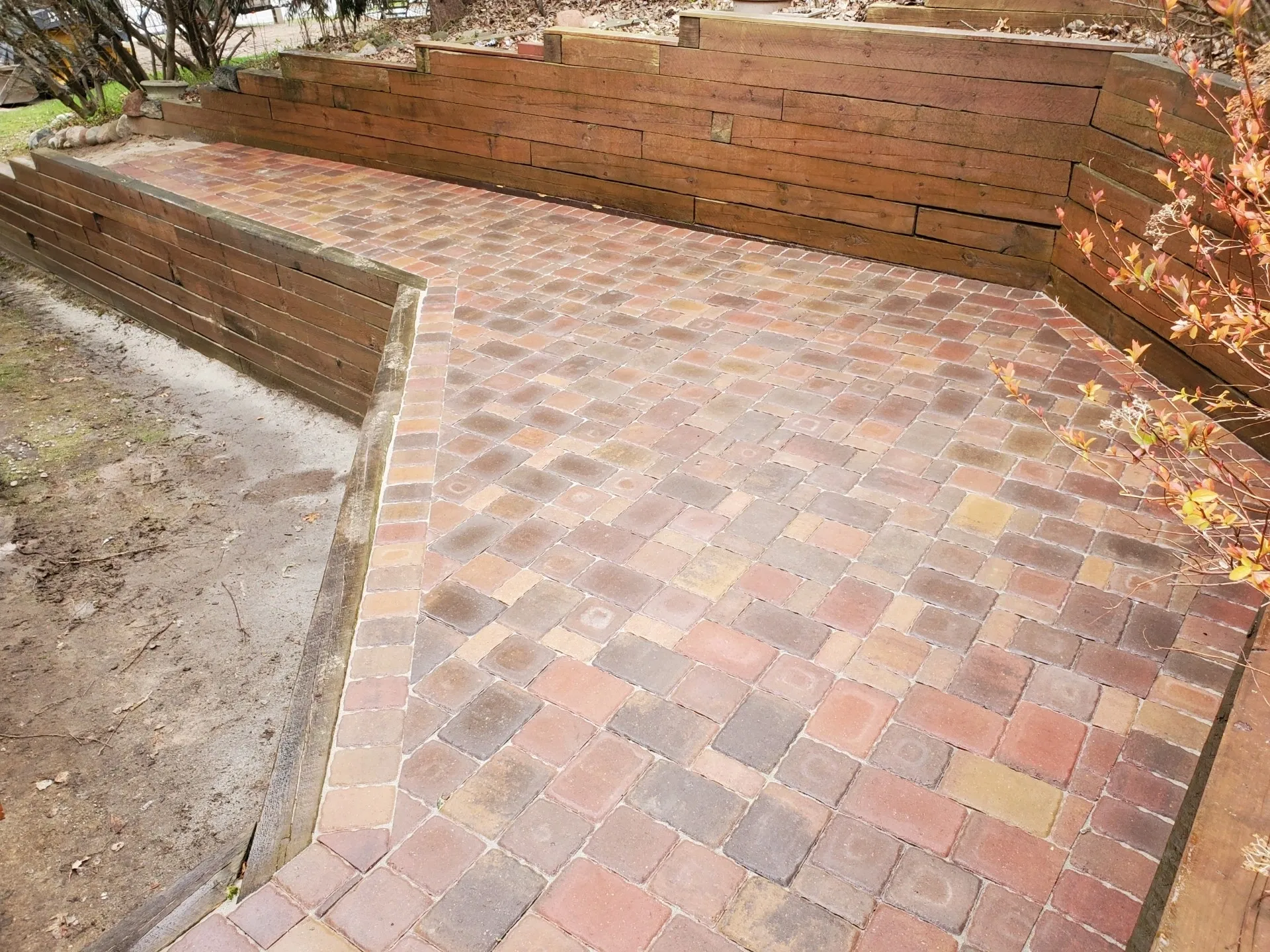 A brick patio with a bench and wall.