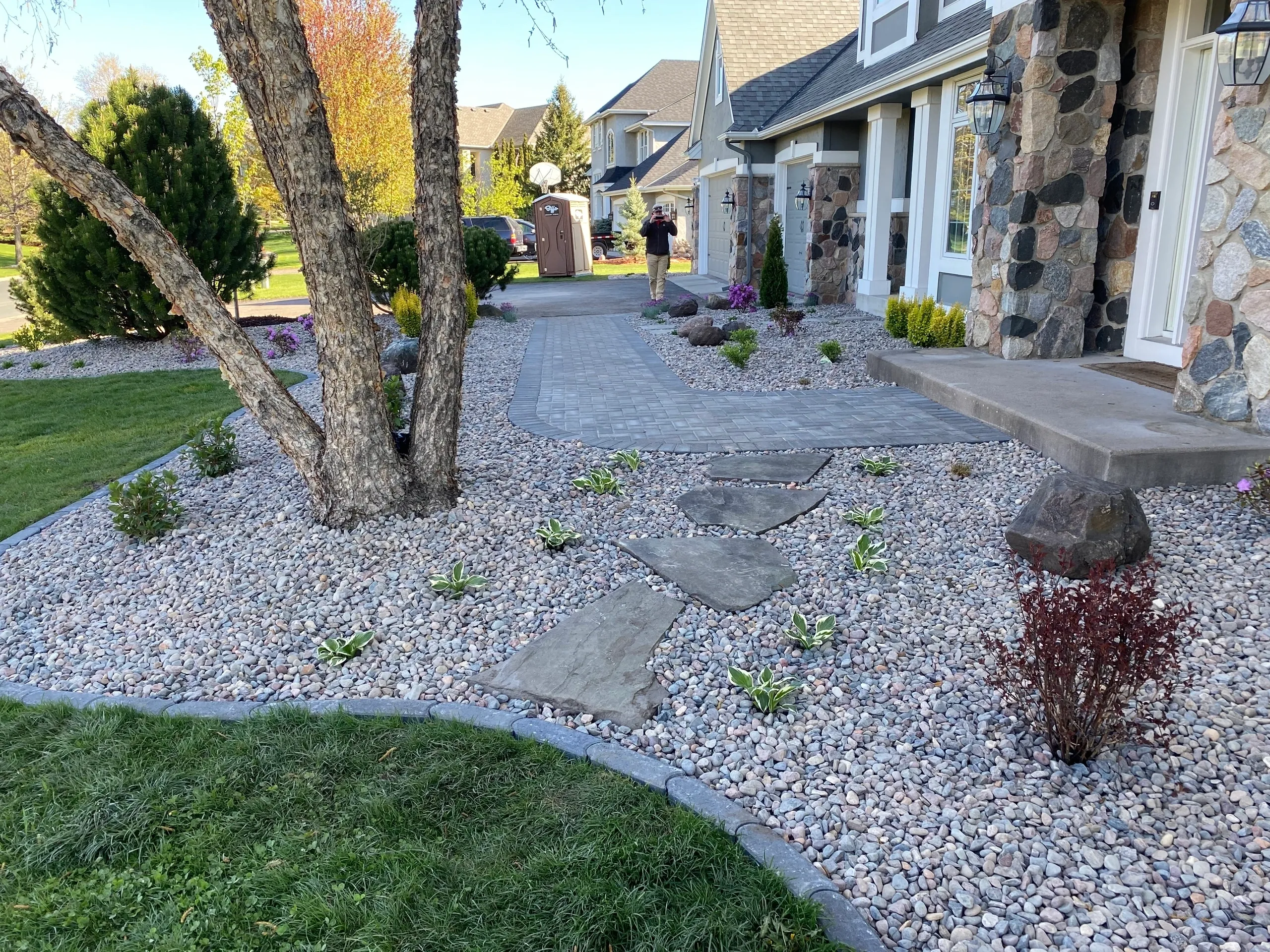 A garden with rocks and plants in the yard.