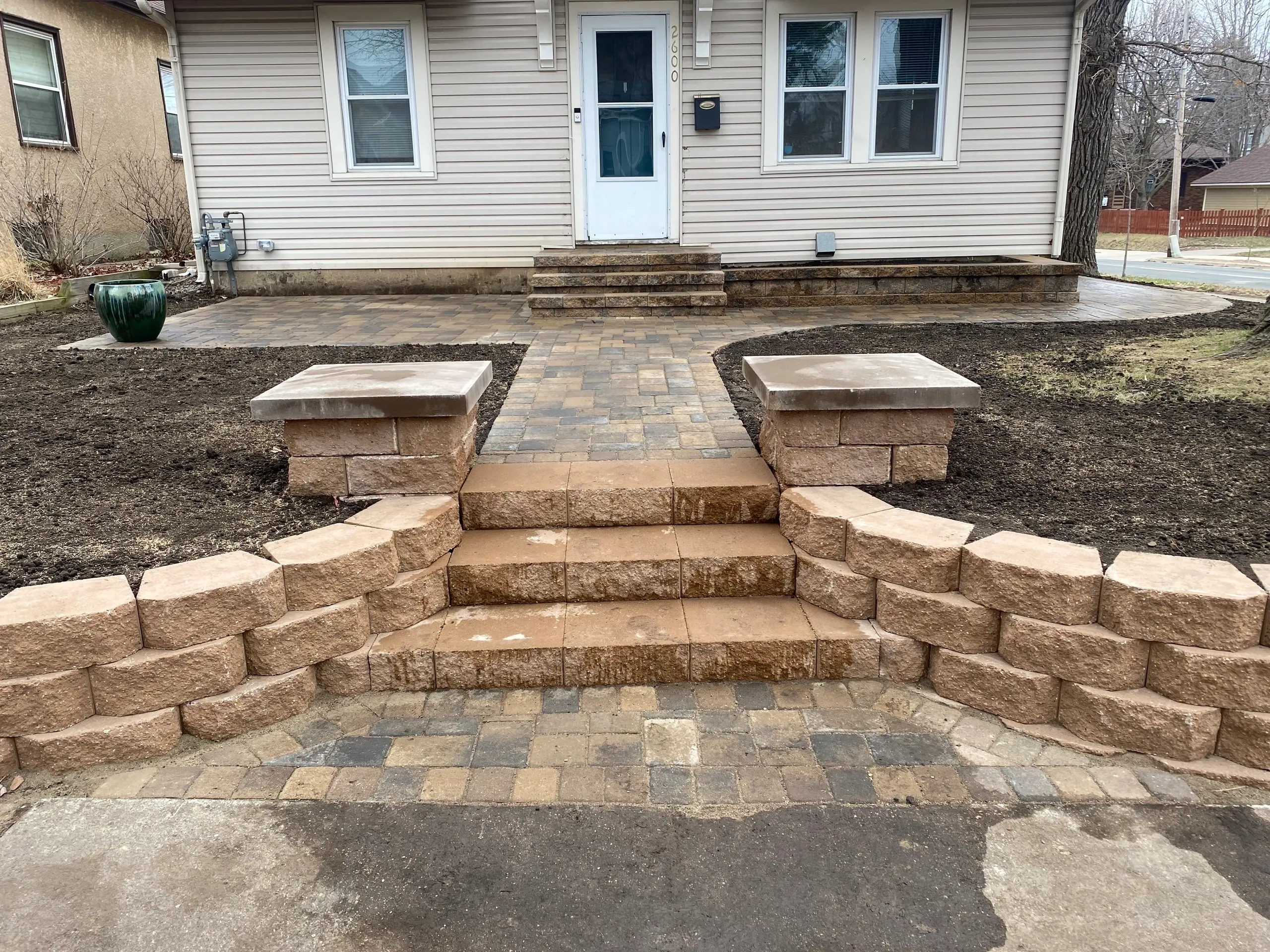 A brick walkway with steps leading to the front of a house.