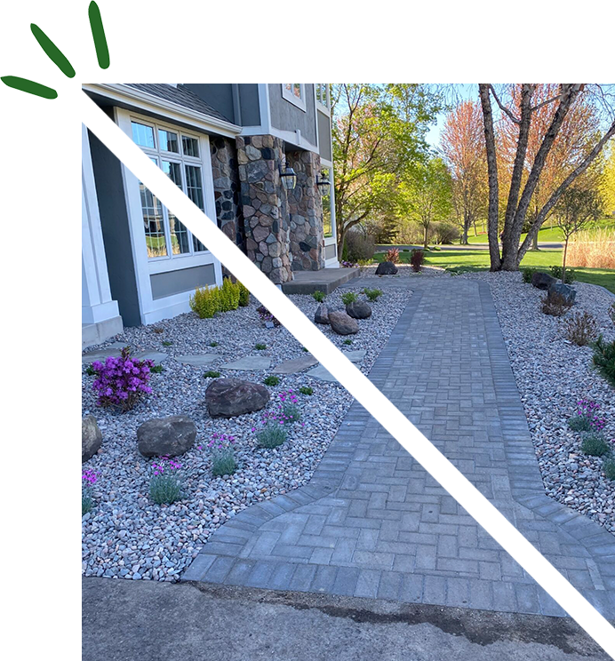 A brick walkway with plants and rocks in the middle of it.